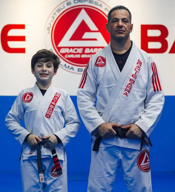 Aluno Kids ao lado do Sensei Henrique Machado, faixa preta
